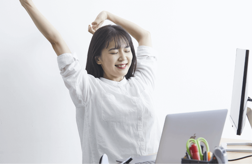 女性が椅子に座って背伸びをしている画像