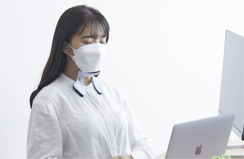 女性が椅子に座ってパワーナップピローをつけて昼寝している様子