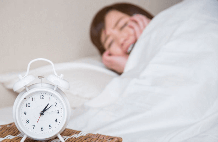 女性がベッドで困っている様子